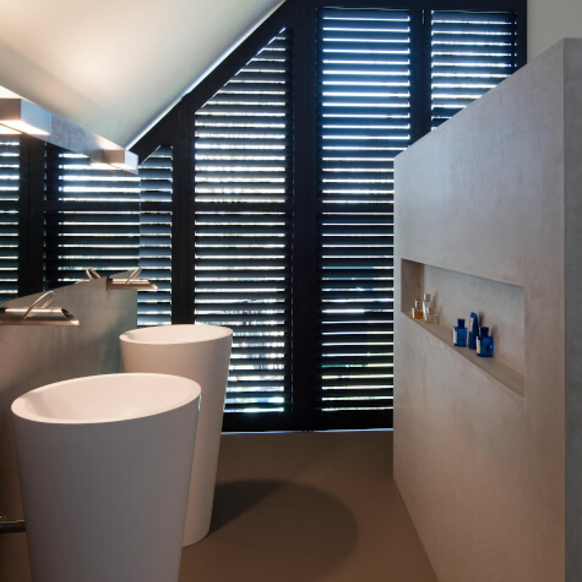 Zwarte shutters voor schuin raam in de badkamer